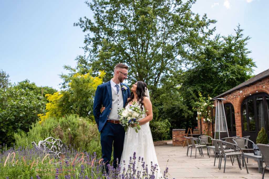 Bride and groom smiling at each other on their wedding day Dodmoor House Northampton