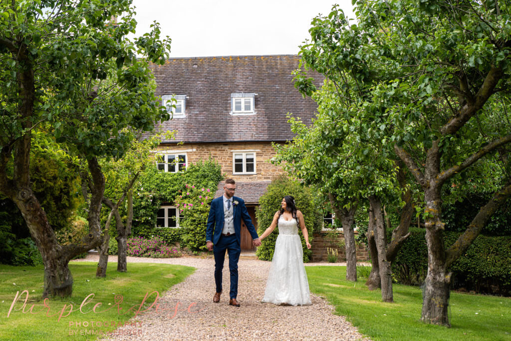 Bride and groom strolling on their wedding day in Northampton