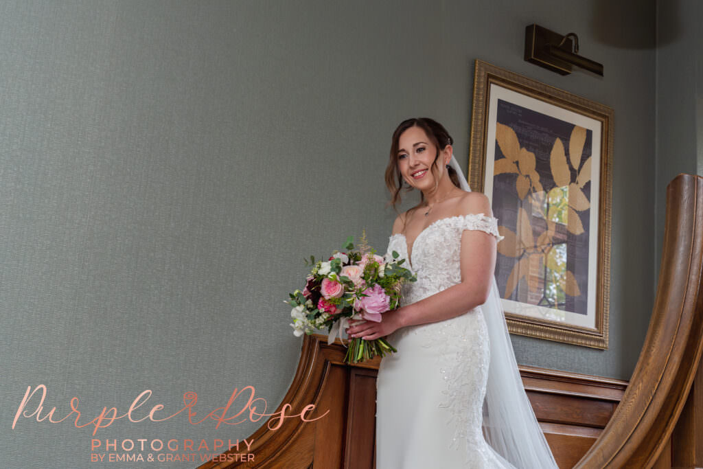 Photo of a bride walking down staircase on her wedding day in Milton Keynes