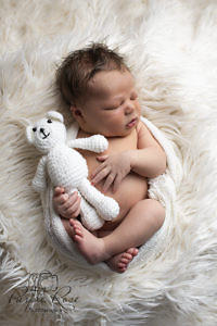 Sleeping baby holding a teddy