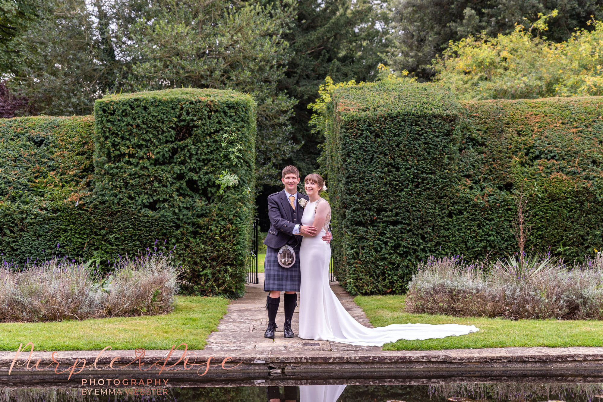 Bride and groom stood by a pond