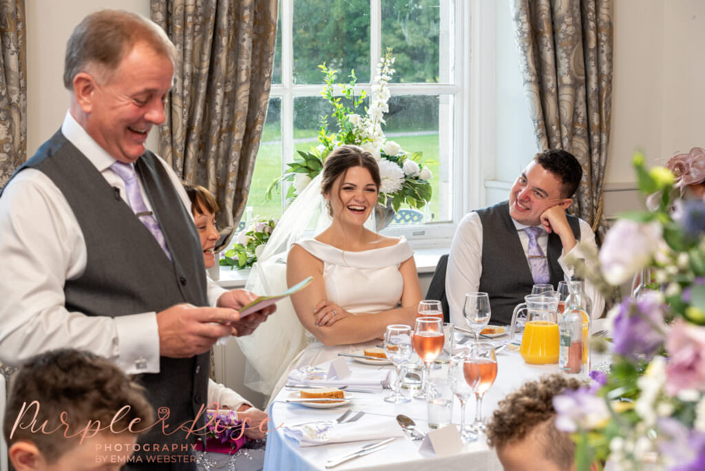 Bride and groom laughing during the father of the brides speech