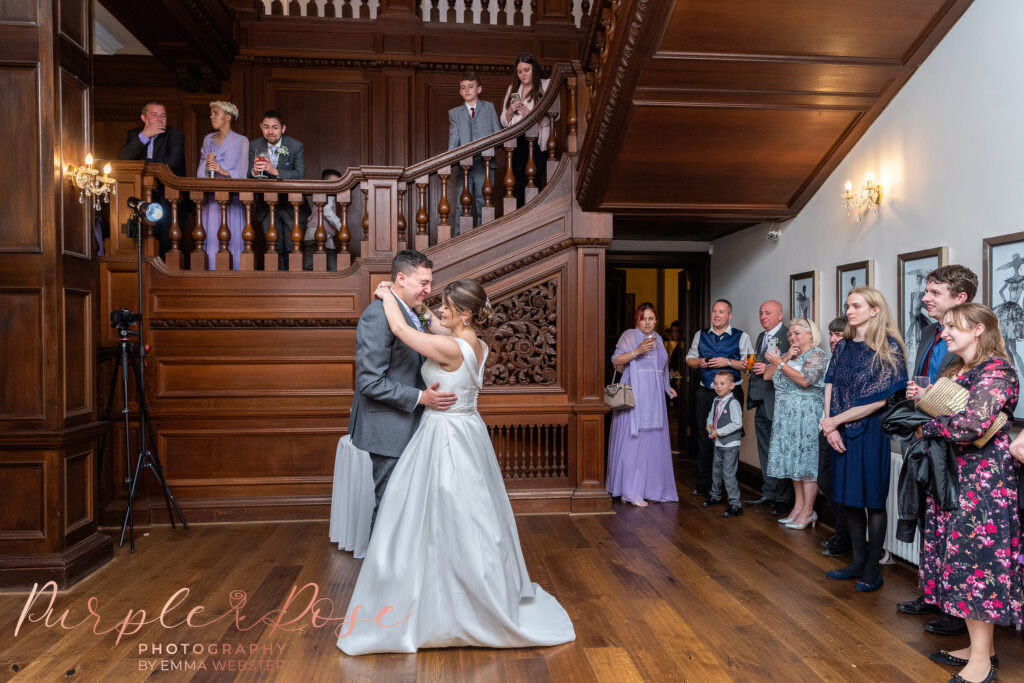 Bride and groom surrounded by wedding guests as they dance on their wedding day at Bourton Hall