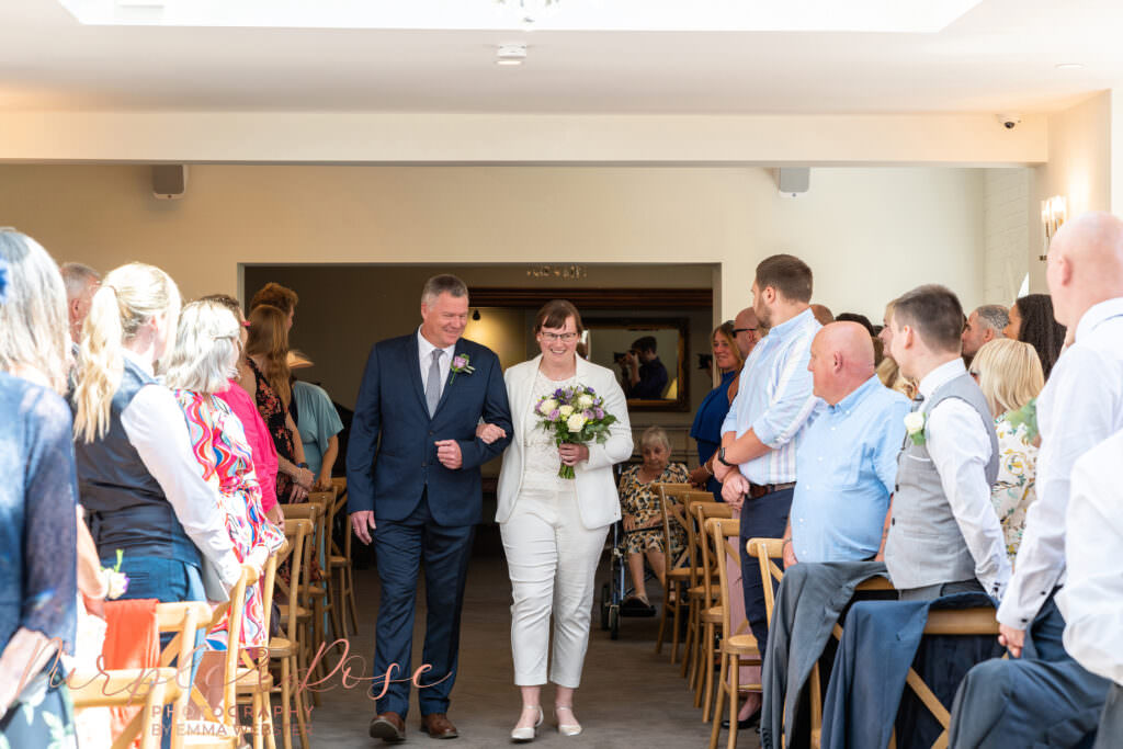 Father and daughter walking into wedding ceremony