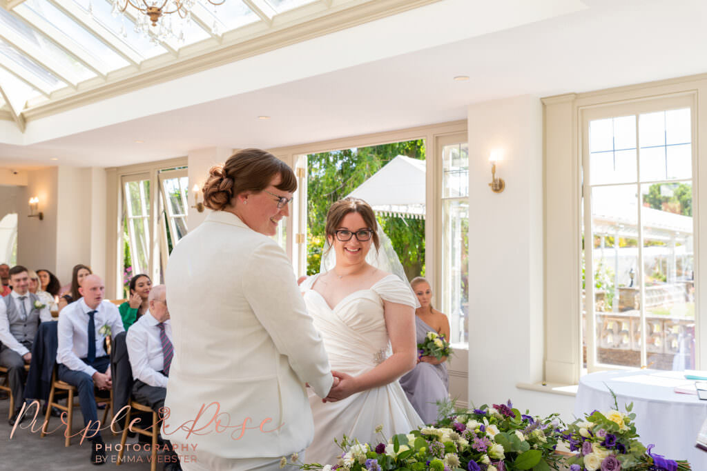 Brides hand in hand during their wedding ceremony