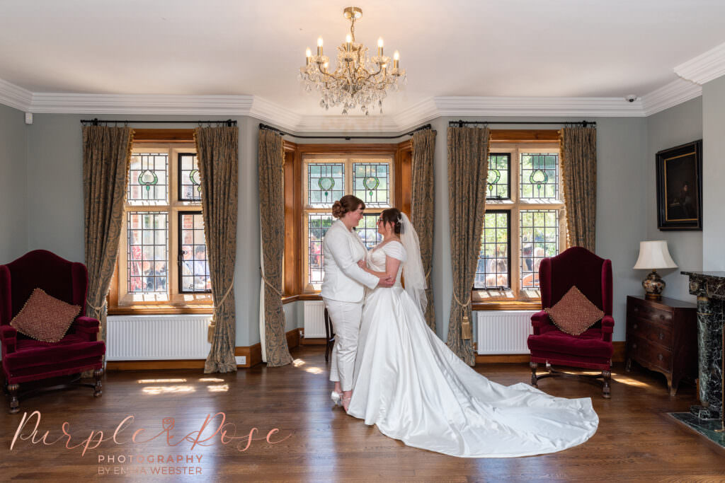 Brides stood under chandelier