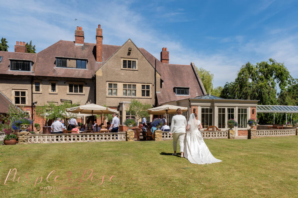 Photograph of 2 Brides walking hand in hand towards their wedding guests on their wedding day in Northampton
