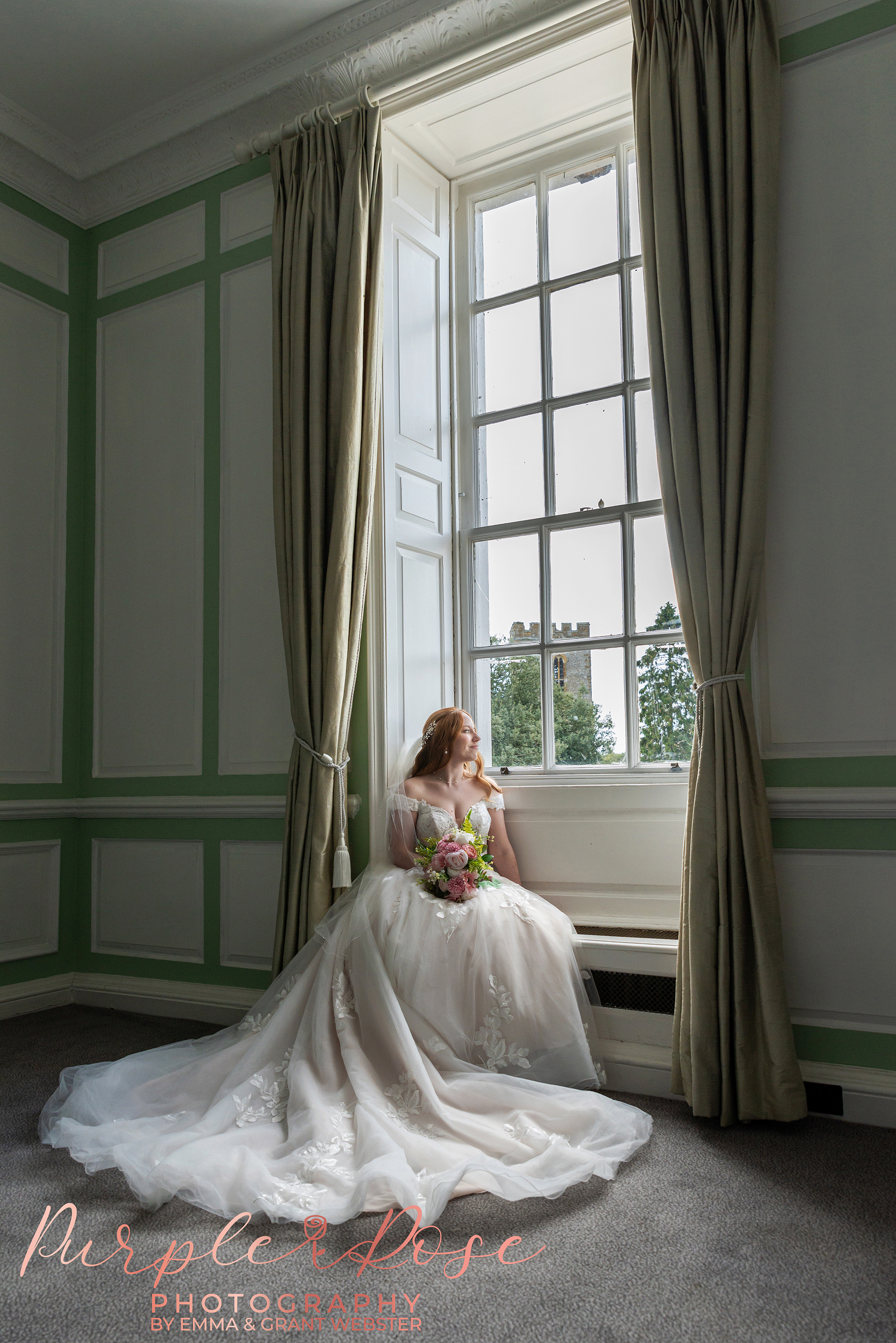 Photo of a bride sat on a window seat on her wedding day at Chicheley Hall in Milton Keynes