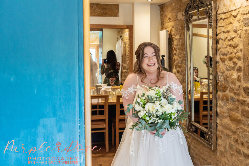Photo of a brides happy reaction as she see's her father for the first time on her wedding day in Northampton