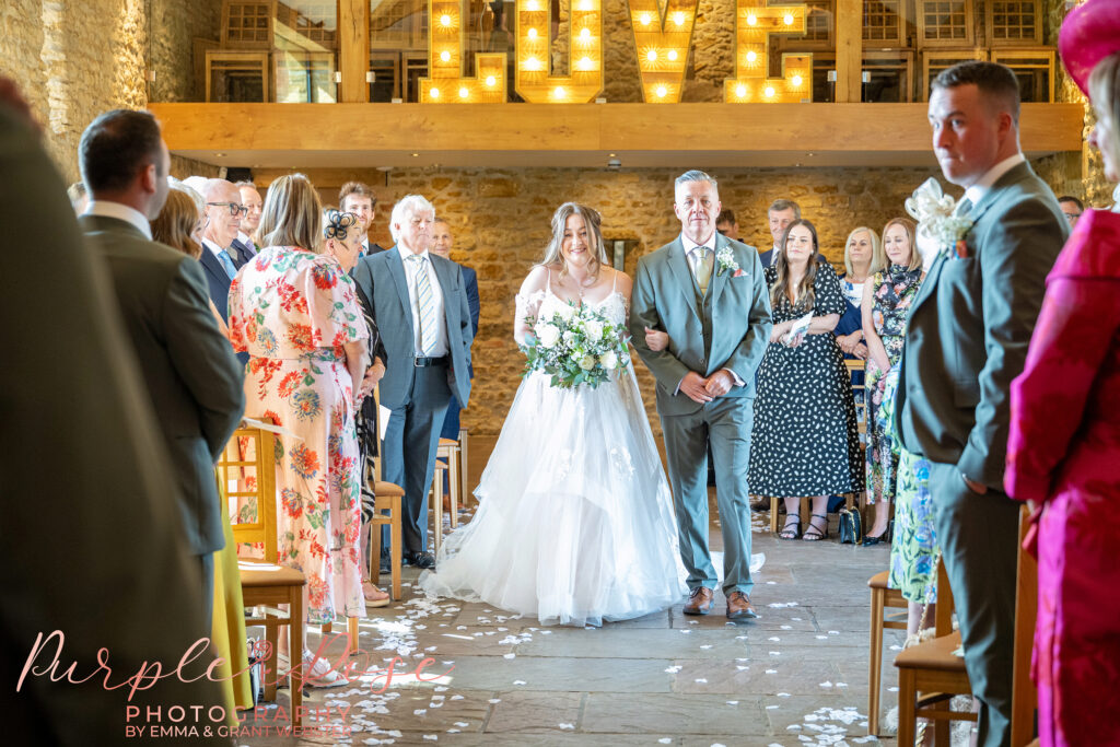 Bride and her father walking down the aisle on her wedding day at Dodford Manor in Northampton