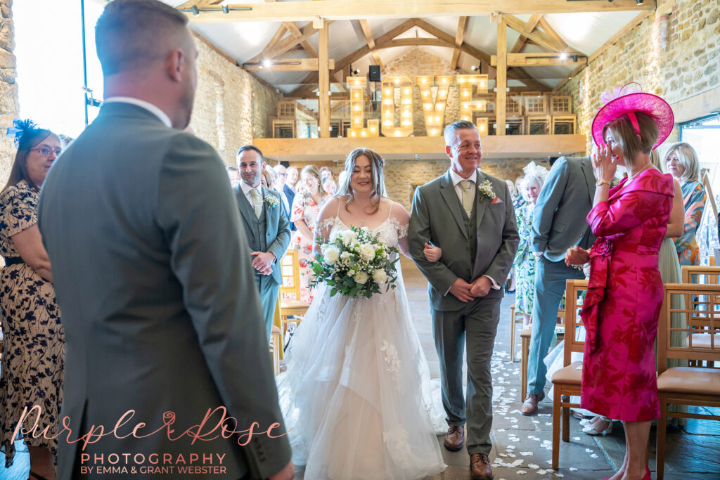 Bride and her father walking down the aisle on her wedding day at Dodford Manor in Northampton