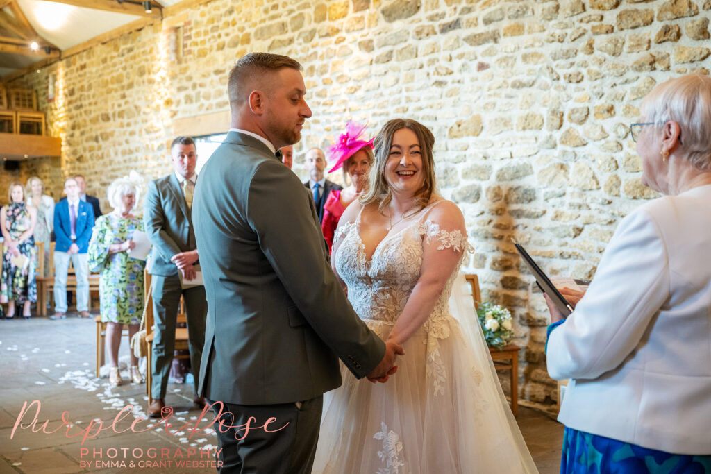 Bride laughing during her wedding ceremony at Dodford Manor