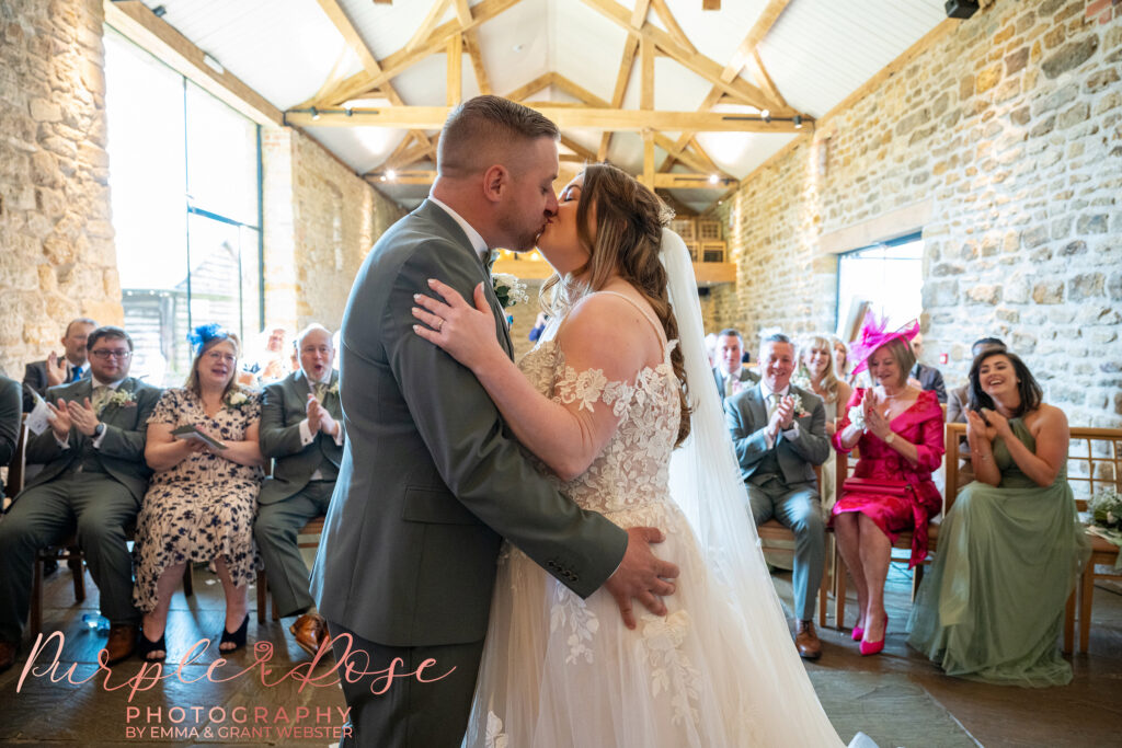 Bride and groom sharing their first kiss on their wedding day at Dodford manor