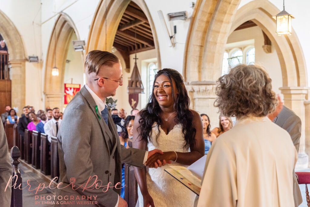 Bride and groom laughing during their church wedding ceremony in Bicester