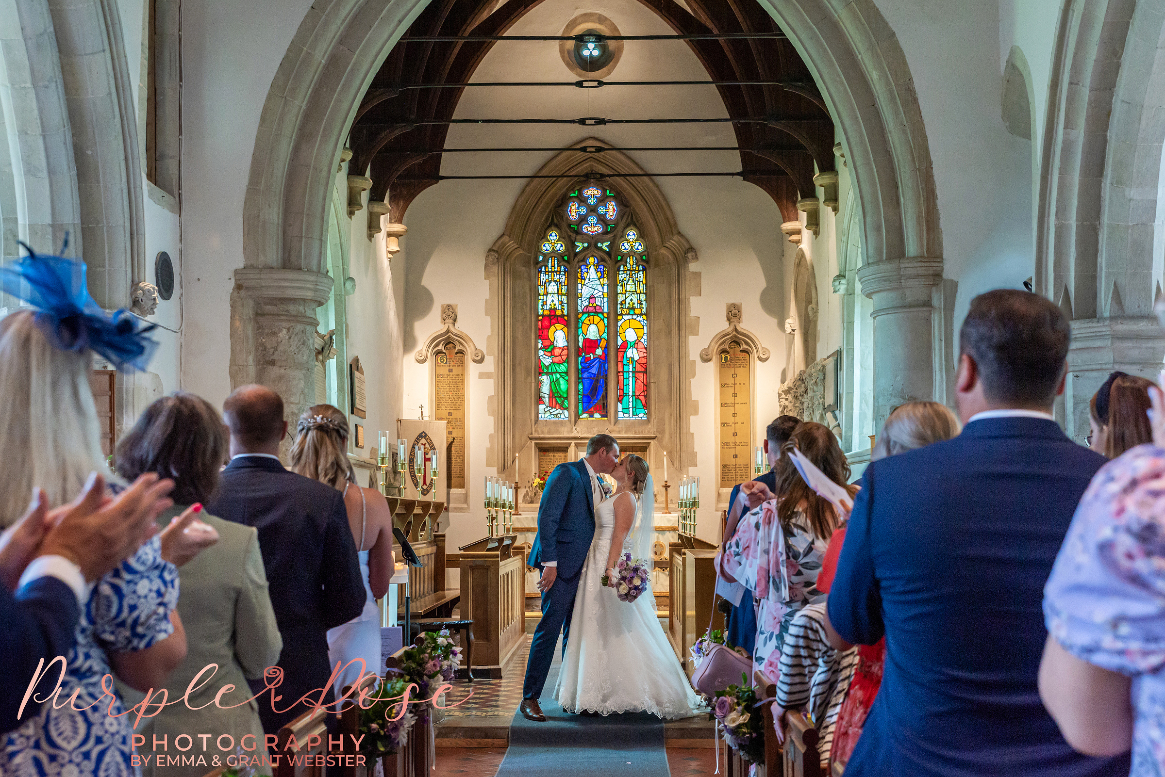 Bride and groom sharing their first kiss as a married couple in their church