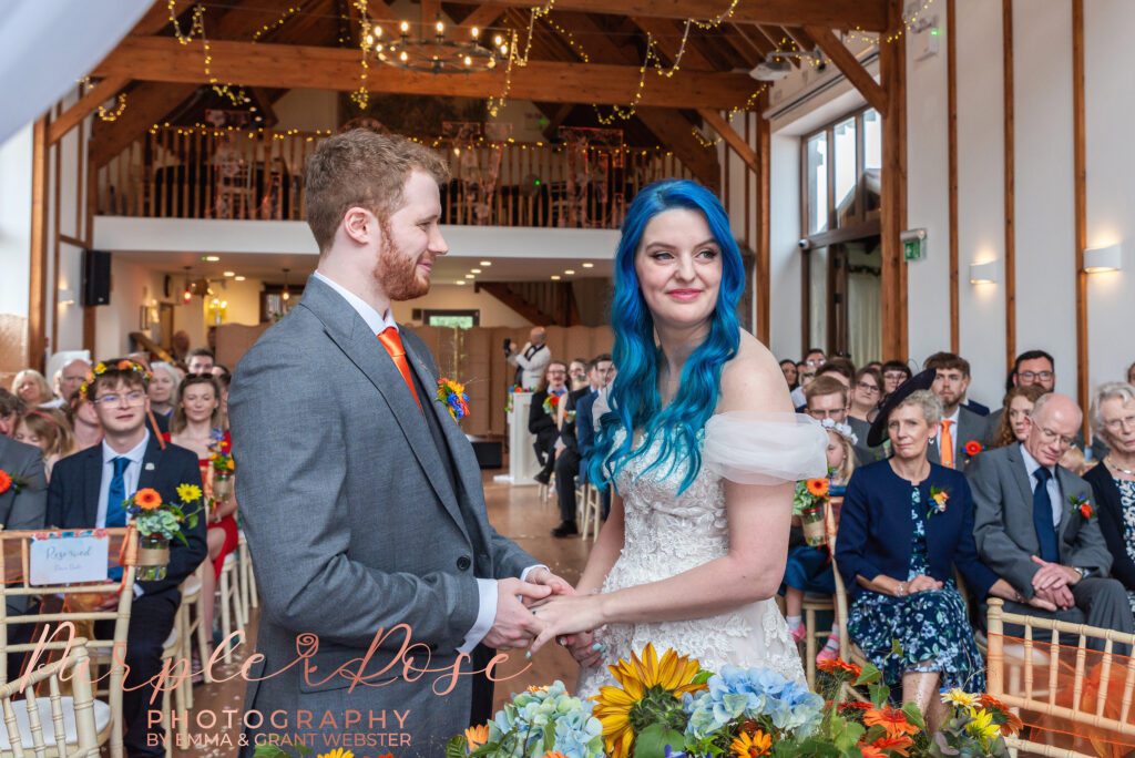 Photo of bride and groom holding hands during their wedding ceremony in Milton Keynes