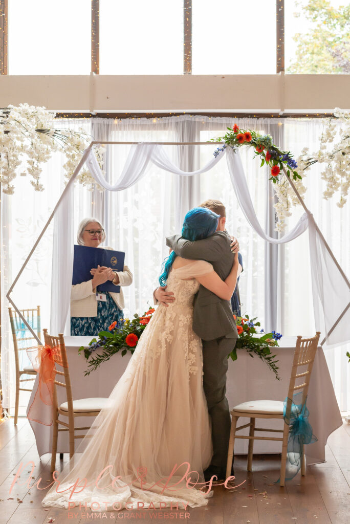 Photo of bride and groom hugging during their wedding ceremony in Milton Keynes