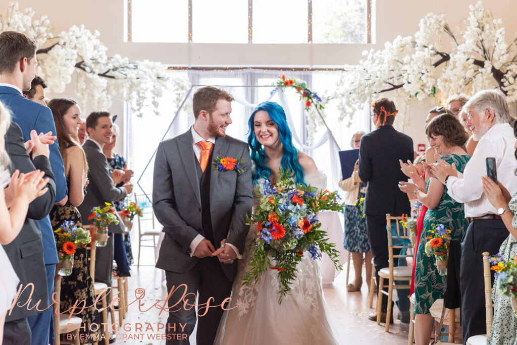 Photo of bride and groom laughing as they leave their wedding ceremony in Milton Keynes