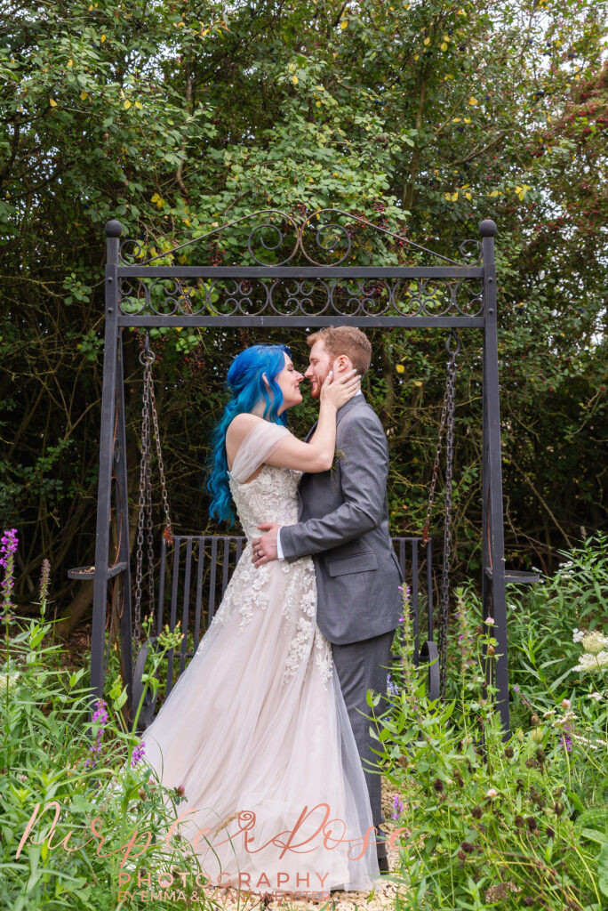 Photo of a bride and groom stood in front of a swing on their wedding day in Milton Keynes