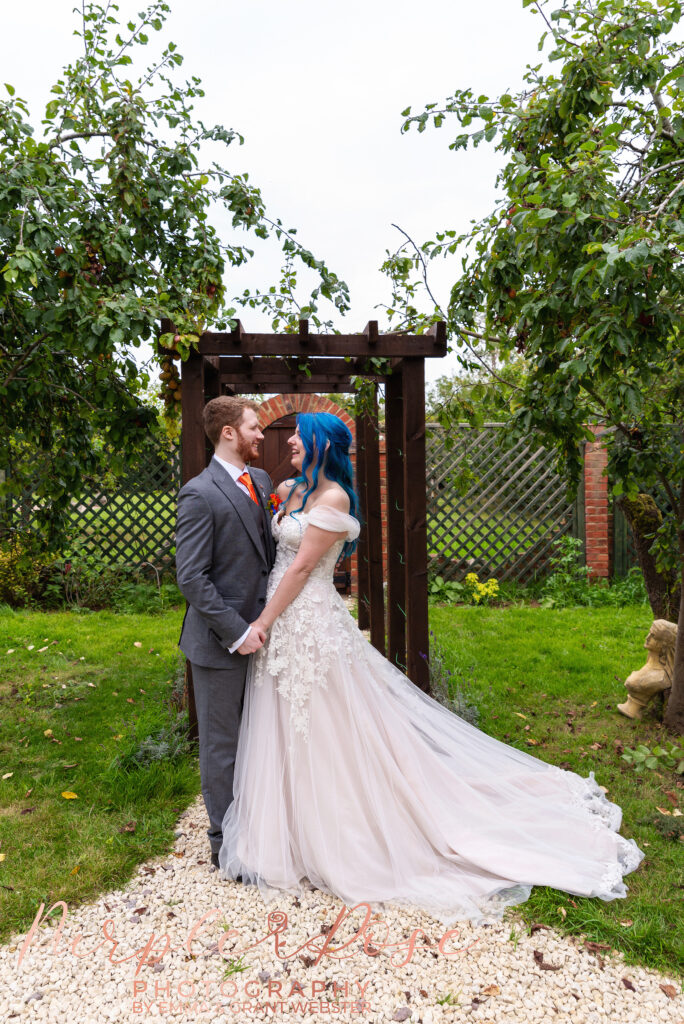 Photo of a bride and groom in frnot of an archway on their wedding day in Milton Keynes