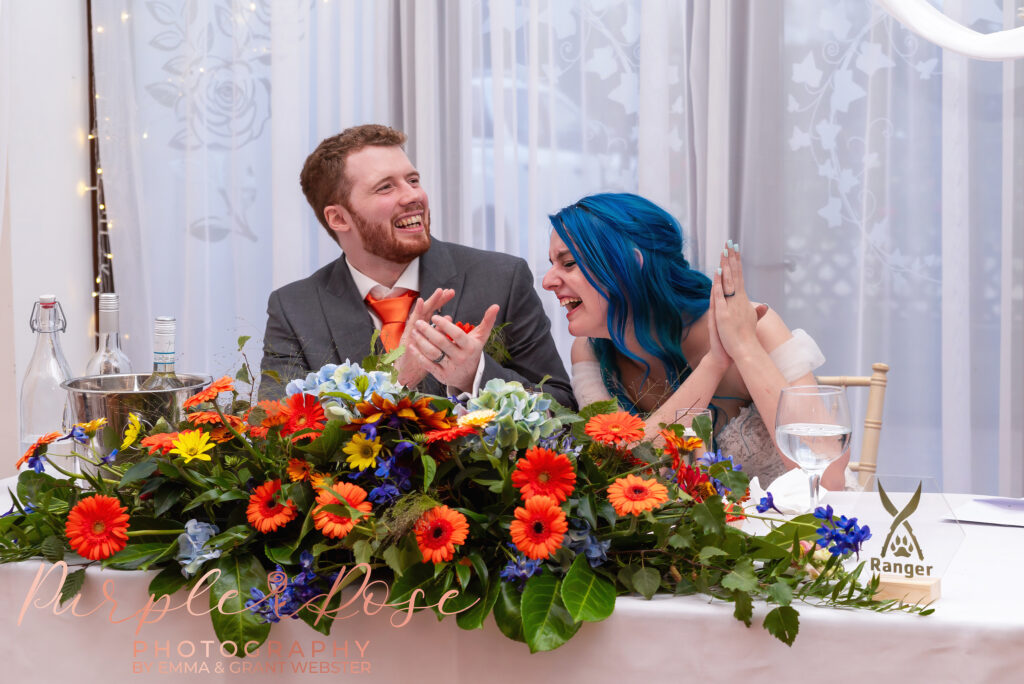 Photo of bride and groom laughing during their wedding speaches on their wedding day in Milton Keynes