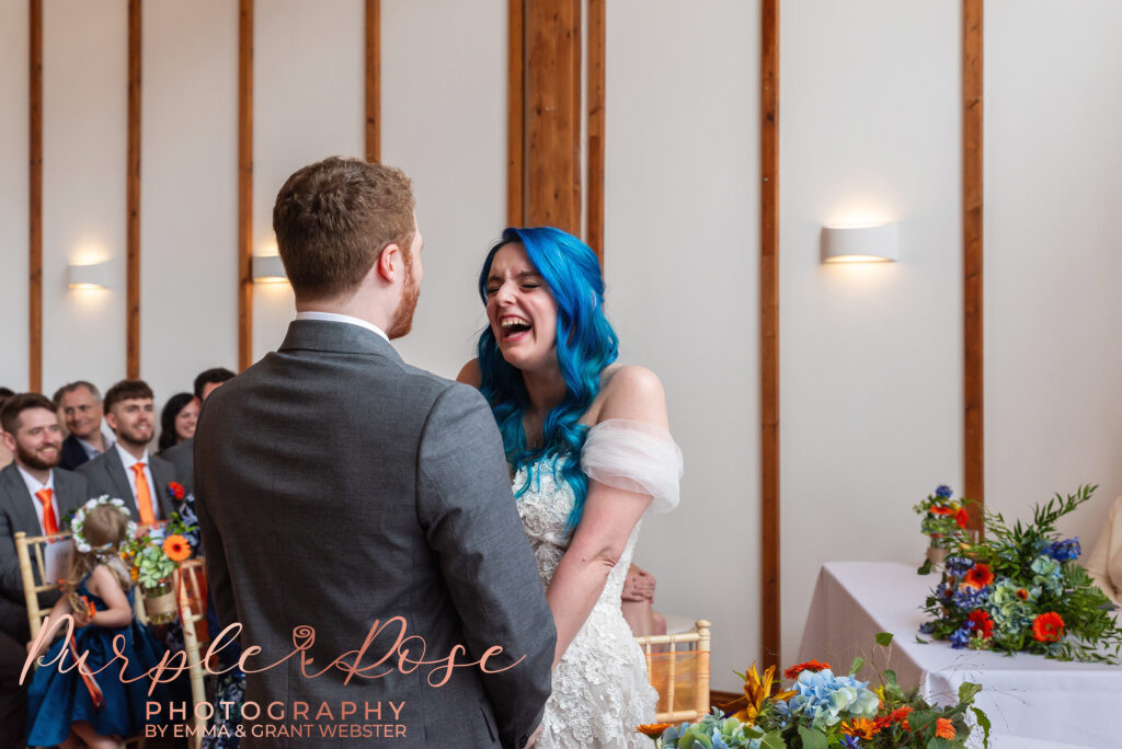 Photo of bride laughing during their wedding ceremony in Milton Keynes