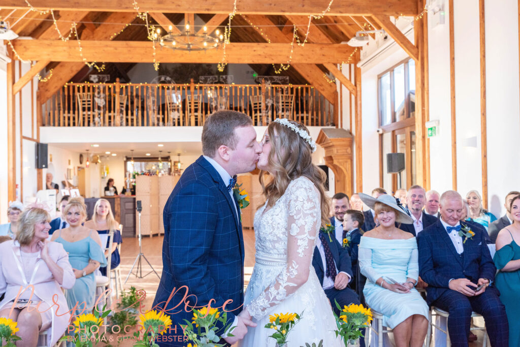 Photo o fbride and groom sharing their first kiss as a married couple in Milton Keynes