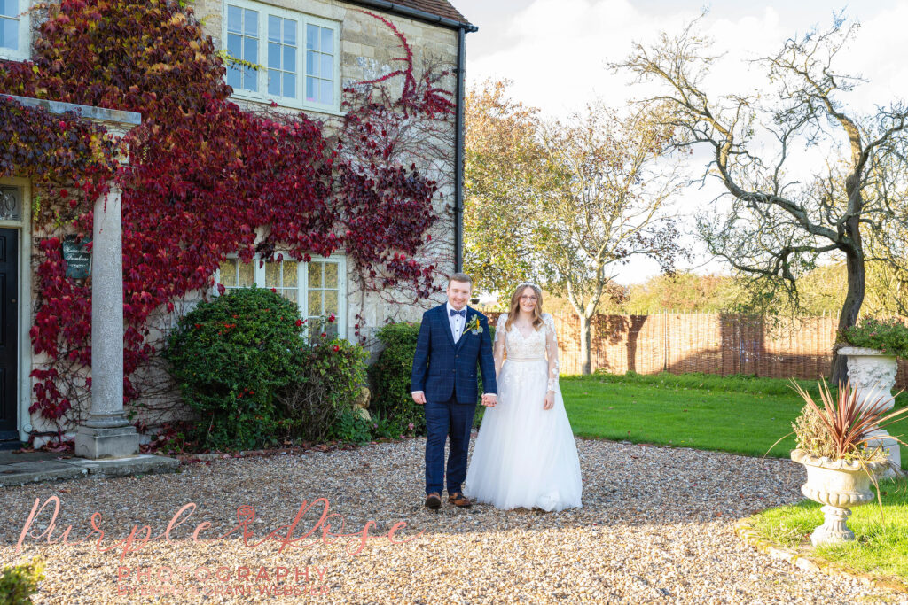 Photo of a bride and groom walking hand in hand on their wedding day in Milton Keynes