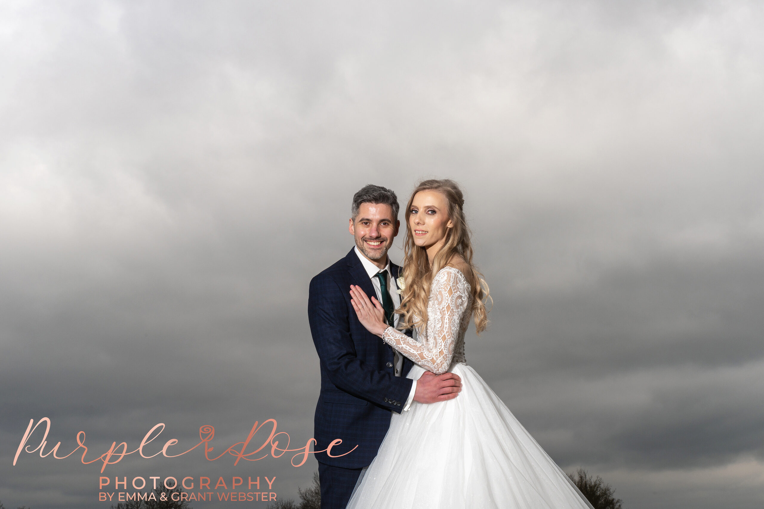 Photo fo bride and groom in front of a stormy sky on their wedding day in Milton Keynes