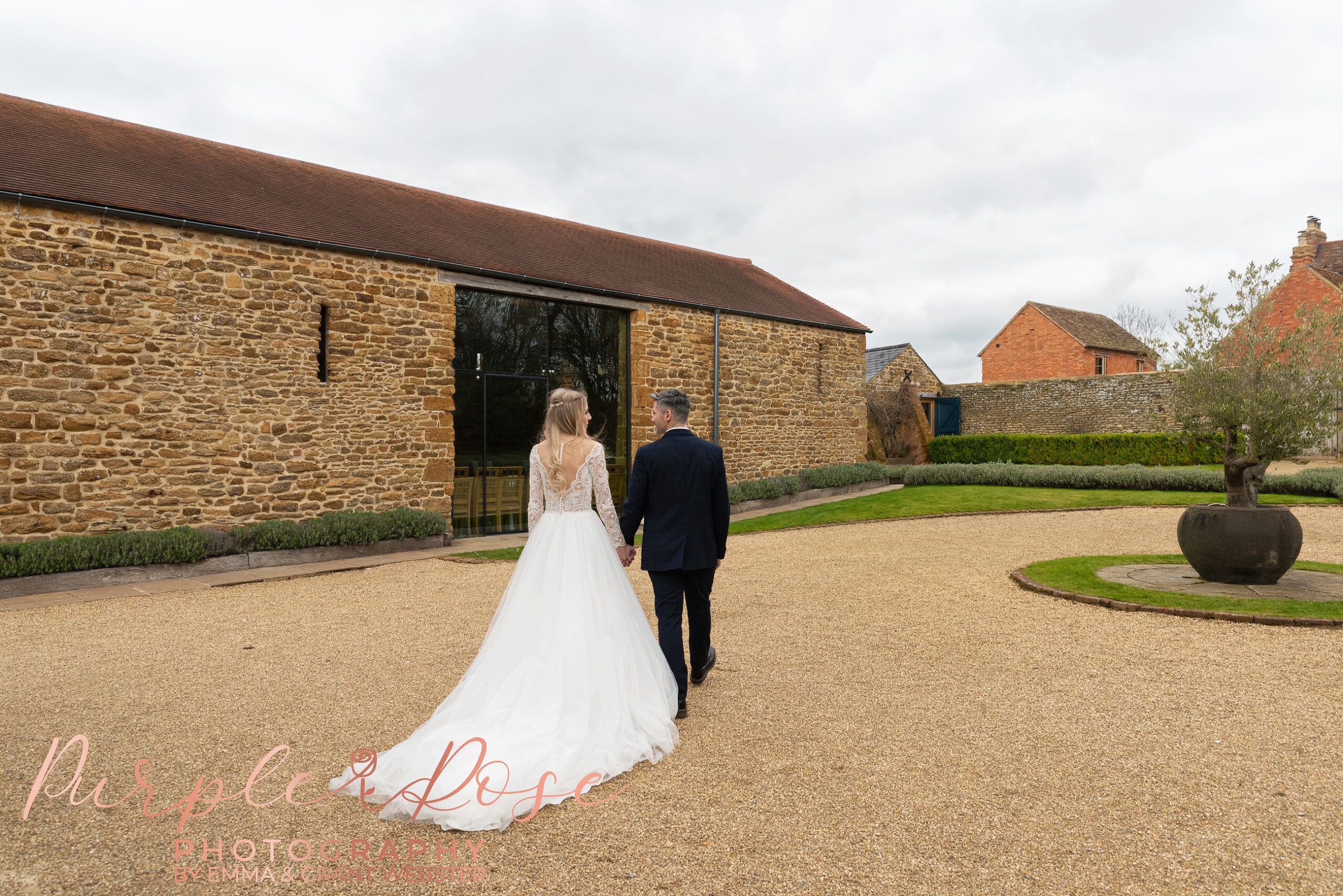 Photo fo a bride and groom walking hand in hand on their wedding day in MIlton Keynes