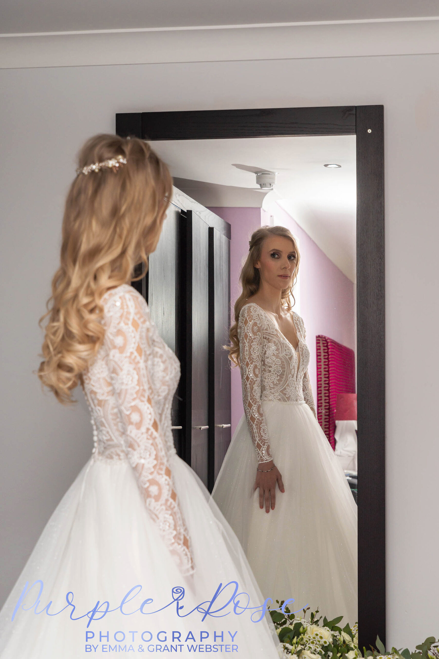 Photo of a bride checking her reflection in a mirrow on her wedding day in Milton Keynes