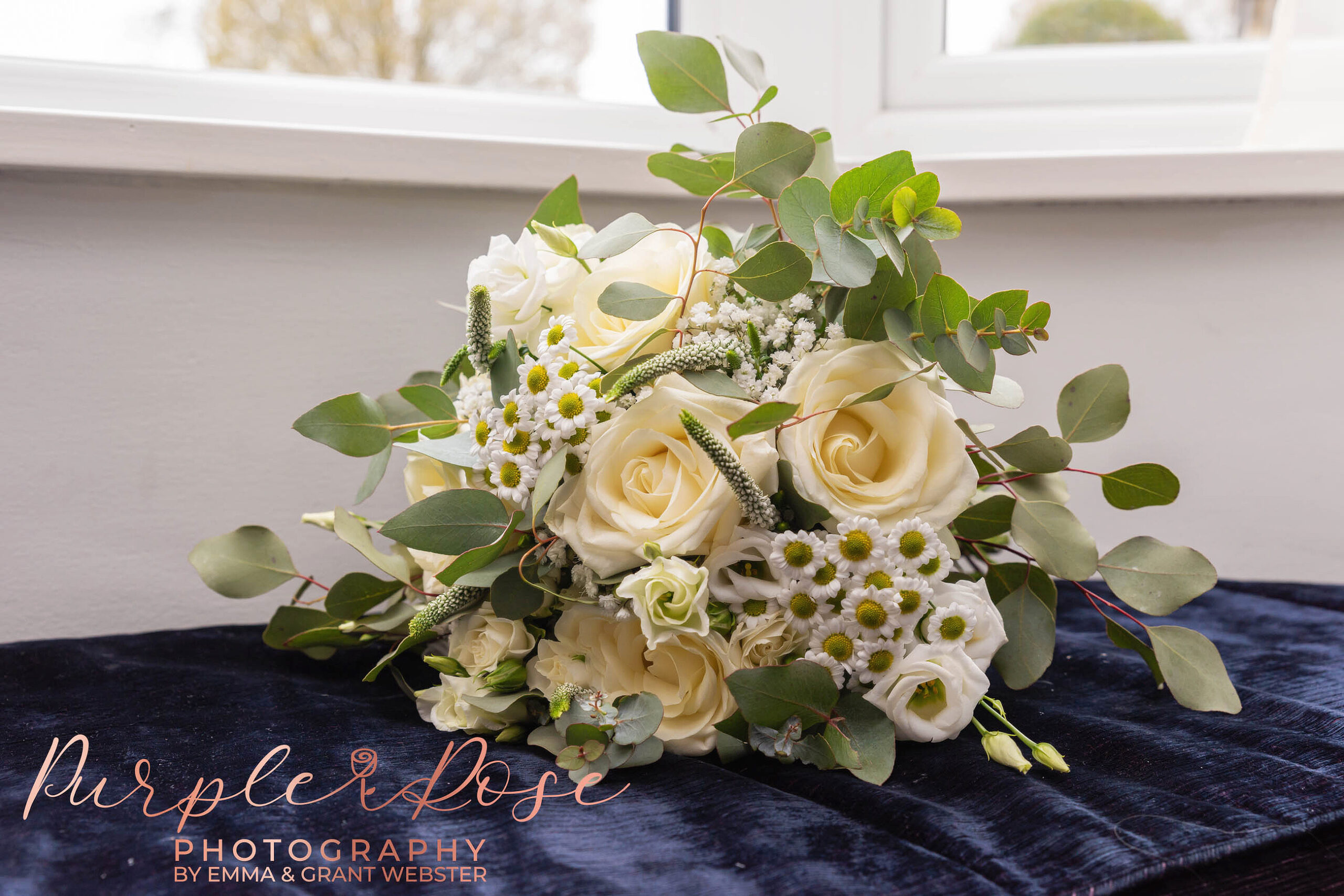 Photo of a brides bouquet by a window on her wedding day in Milton Keynes