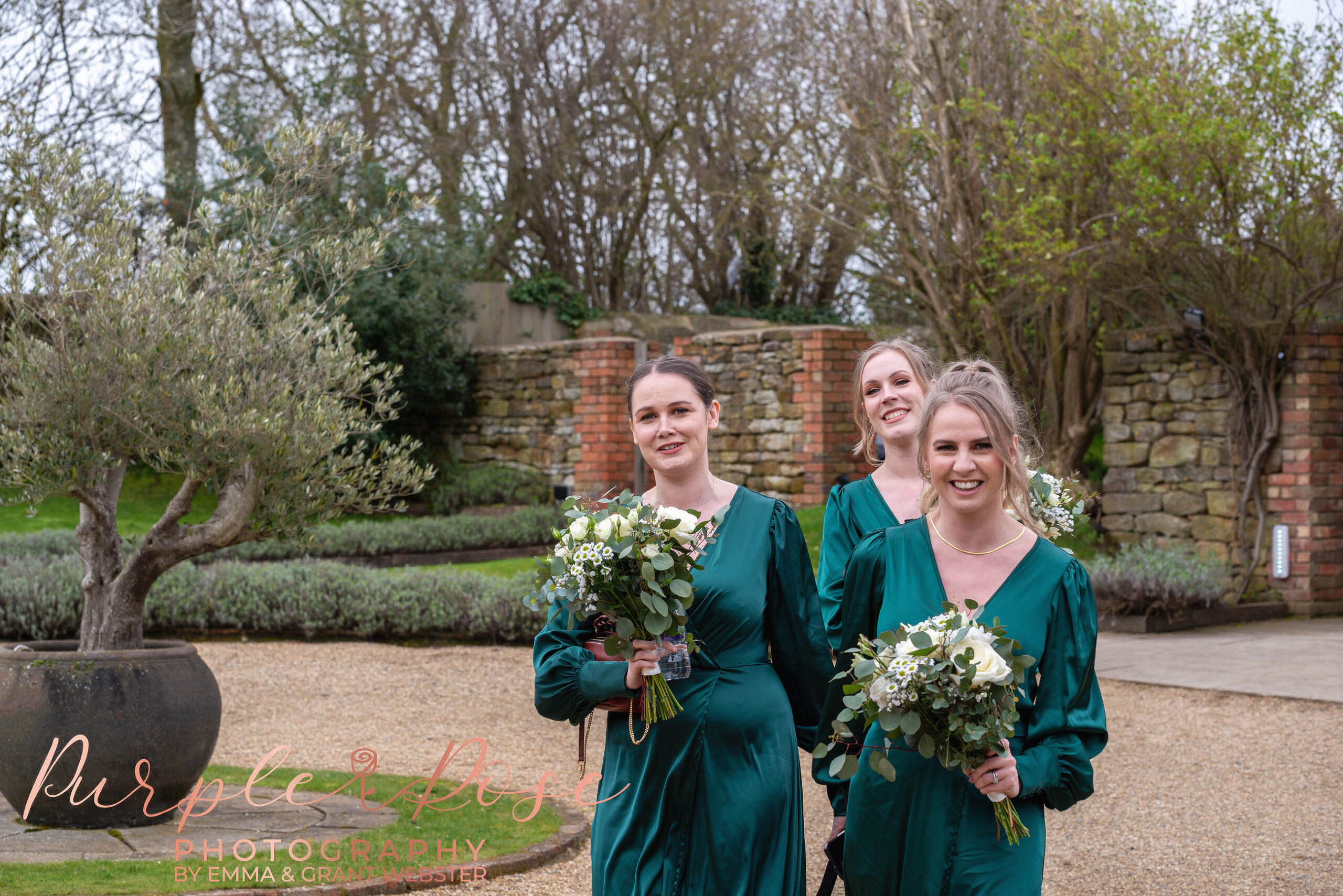 Photo of brides mads walking to the wedding ddressed in green dresses at a wedding in Milton Keynes