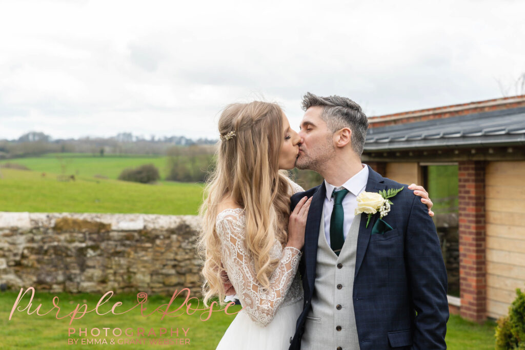 Phot of a bride and groom kissing outside their wedding venue in Milton Keynes