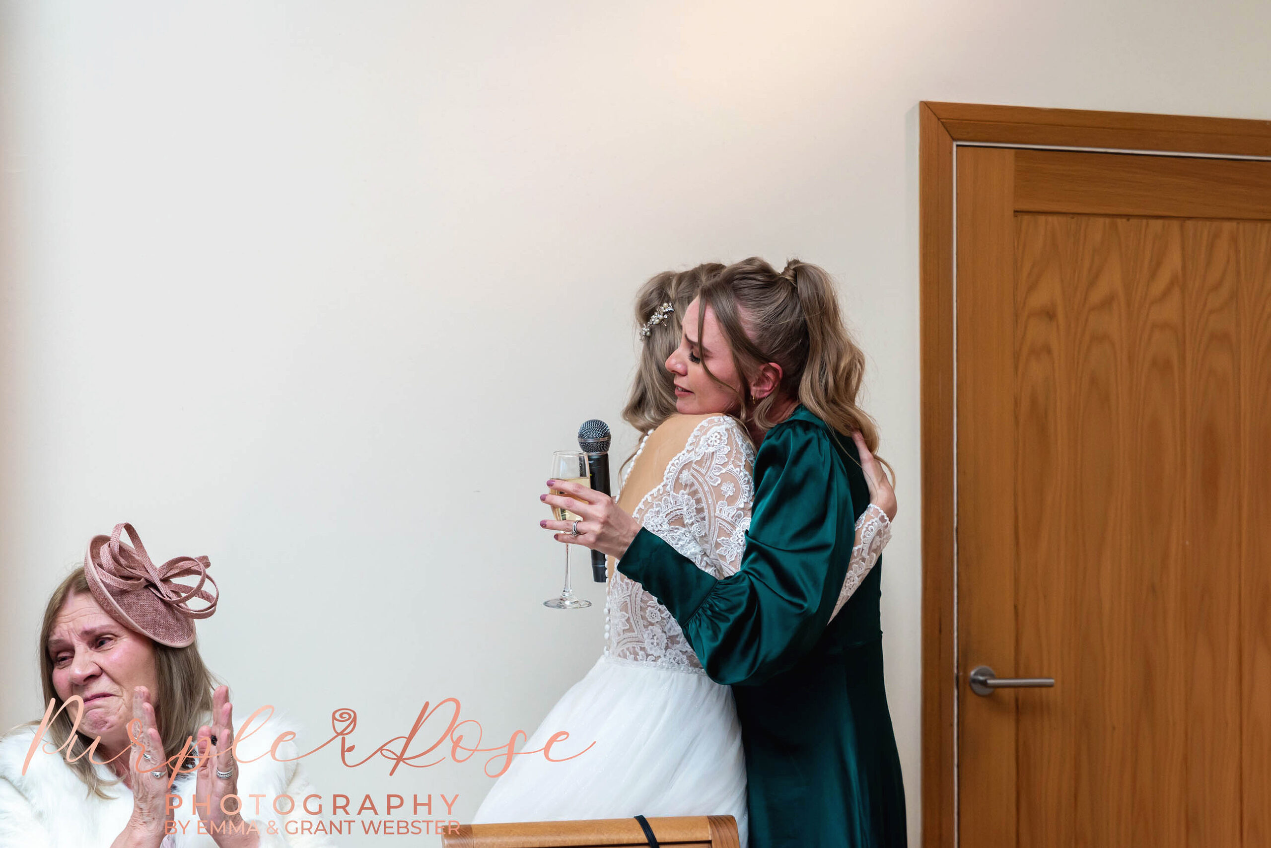 Bride hugging her bridesmaid during a wedding in Milton Keynes