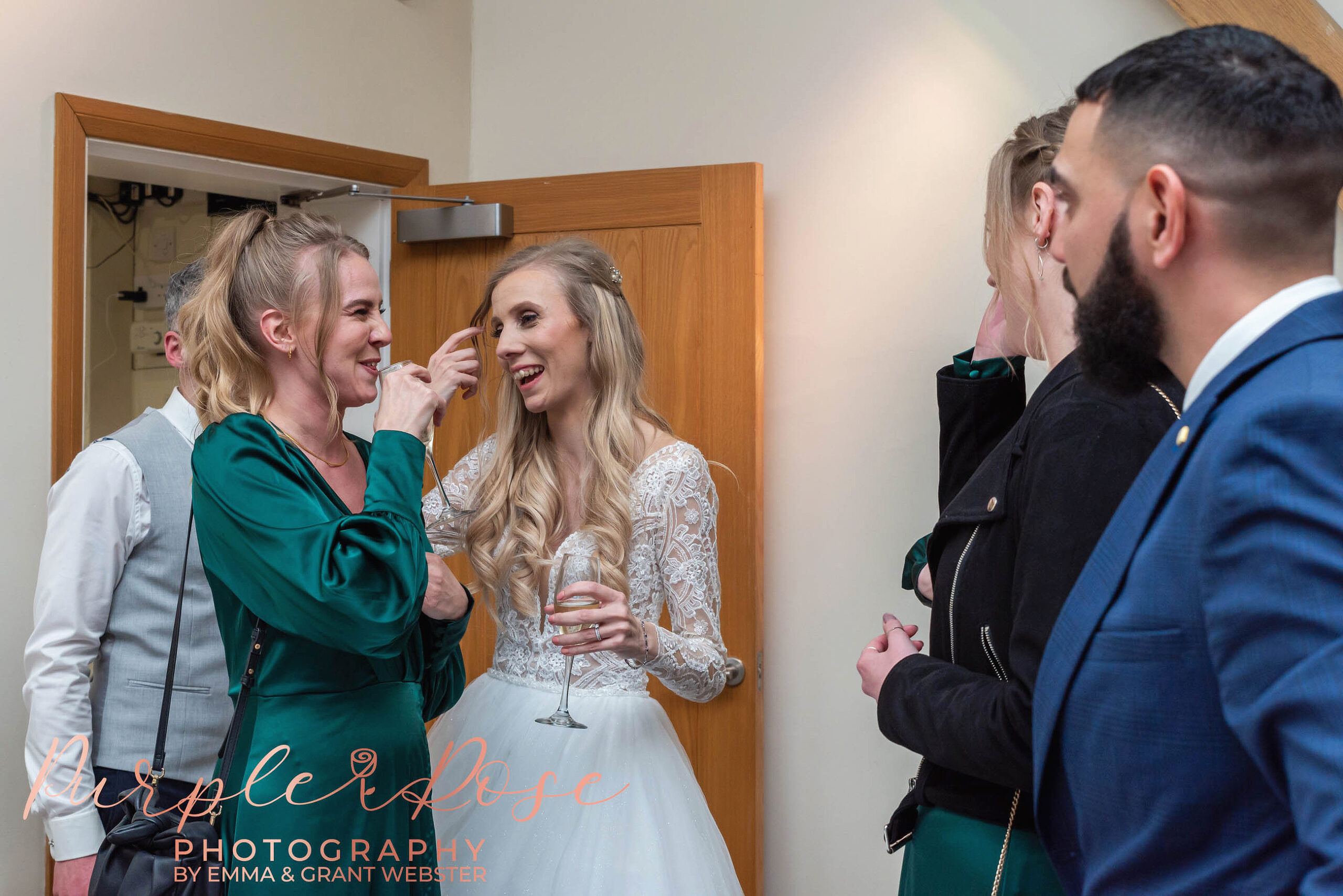 Photo of a bride laughing with her bridesmaid at a wedding in Milton Keynes