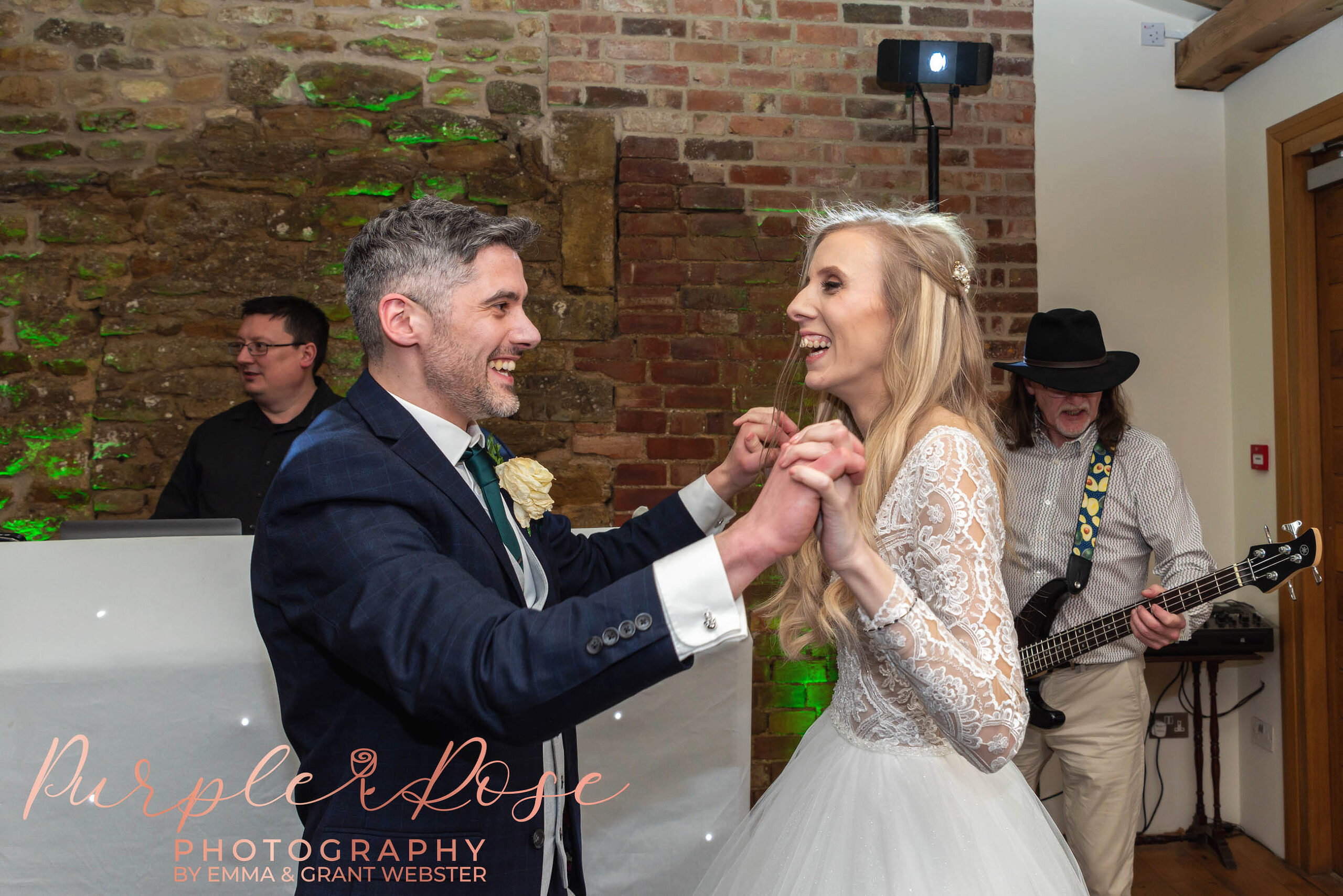 Photo of a bride and groom laughing as they dance their first dance on their wedding day in Milton Keynes