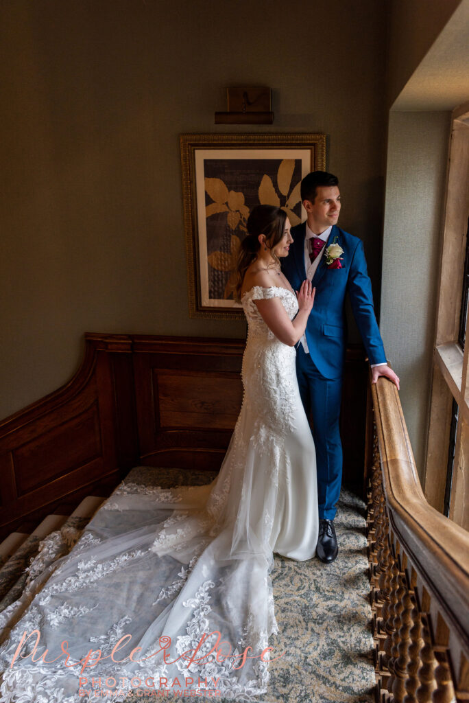 Photo of a bride and groom looking out of a window on a staircase on their wedding day at Horwood House in Milton Keynes