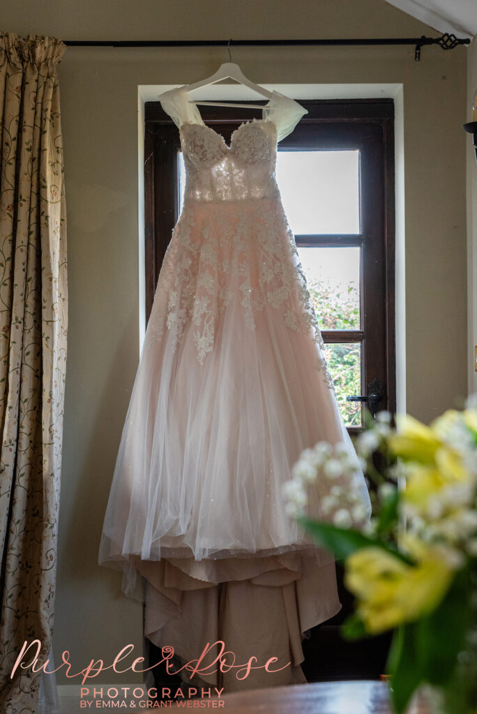 Photo of a wedding dress hanging in a window at a wedding in Milton Keynes