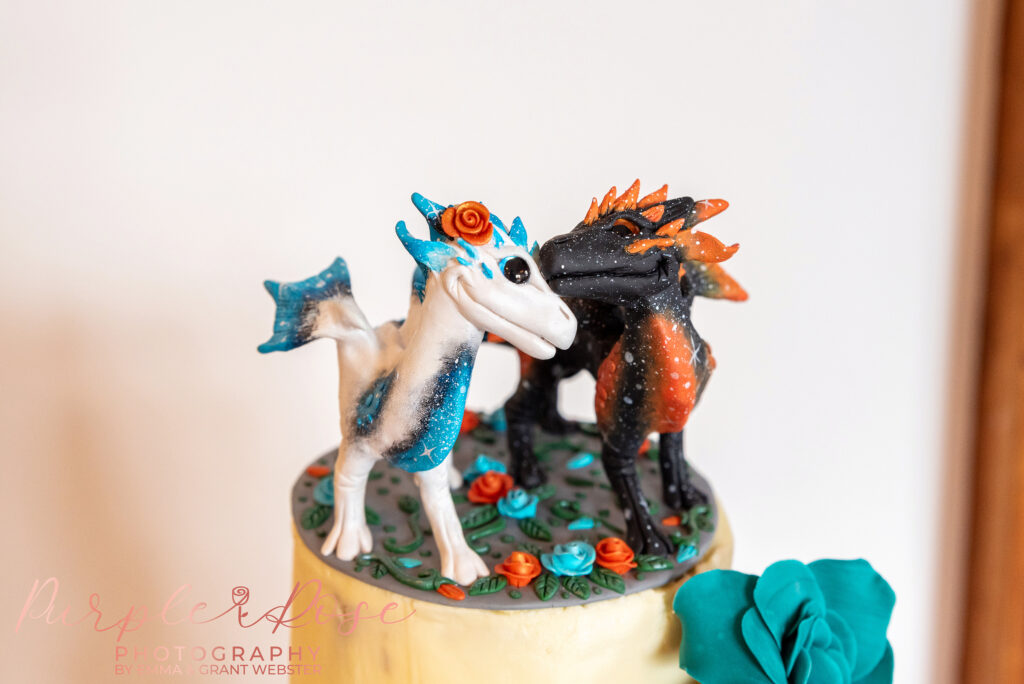 Photo of dragon figures on a wedding cake on a wedding day in Buckinghamshire