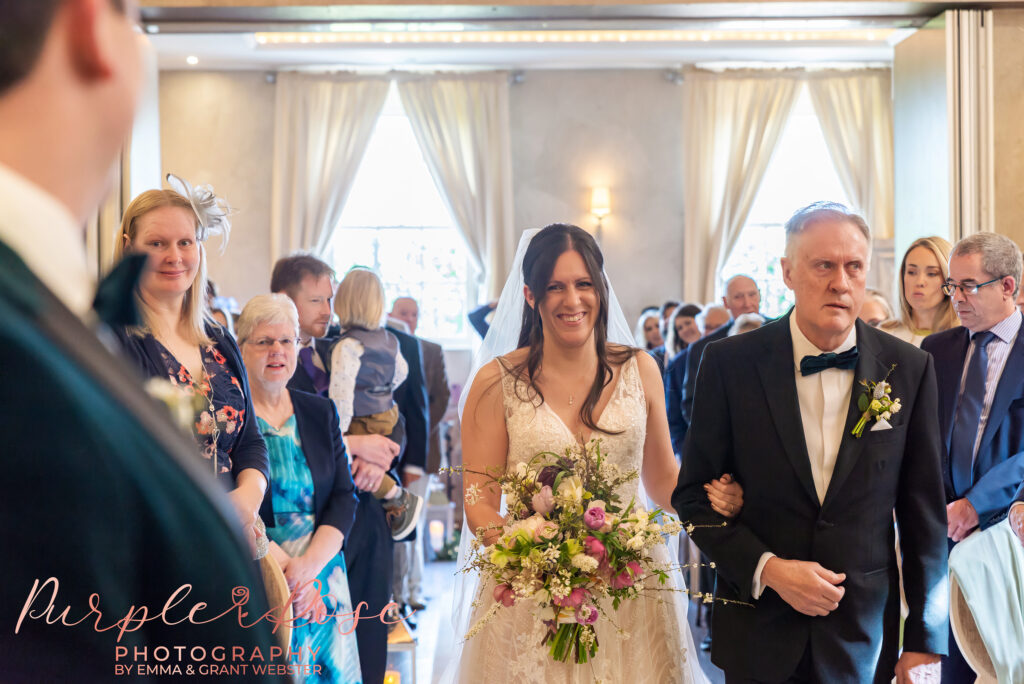 Photo of a bride smiling as she see's her groom on their wedding day in Northampton