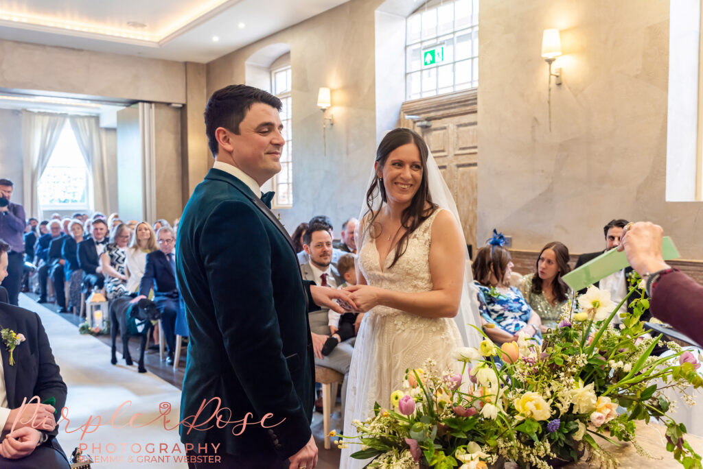 Photo of a bride and groom during the ring exchange at their wedding ceremony in Northampton