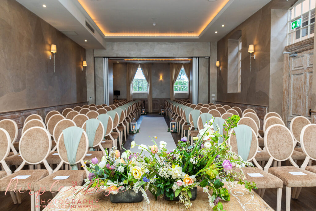 Photo of wedding ceremony room set up and ready with flowers and green ties at a wedding in Northampton