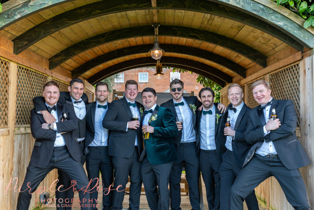 Photo of a groom and his grooms holding drink at his wedding in Northampton