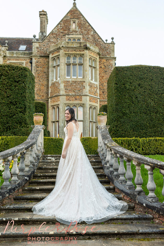 Photo of a bride looking over he shoulder on staircase outside their wedding venue in Northampton 