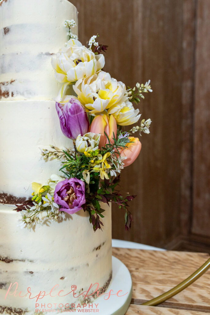 Photo of a cake decorated with spring flowers at a wedding in Northampton