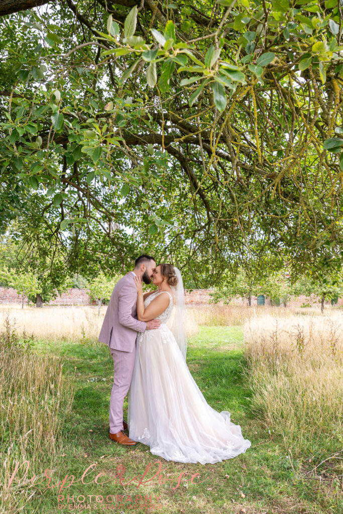 Photo of a bride and groom kissing whilst in the grounds of Chicheley Hall in Milton Keynes