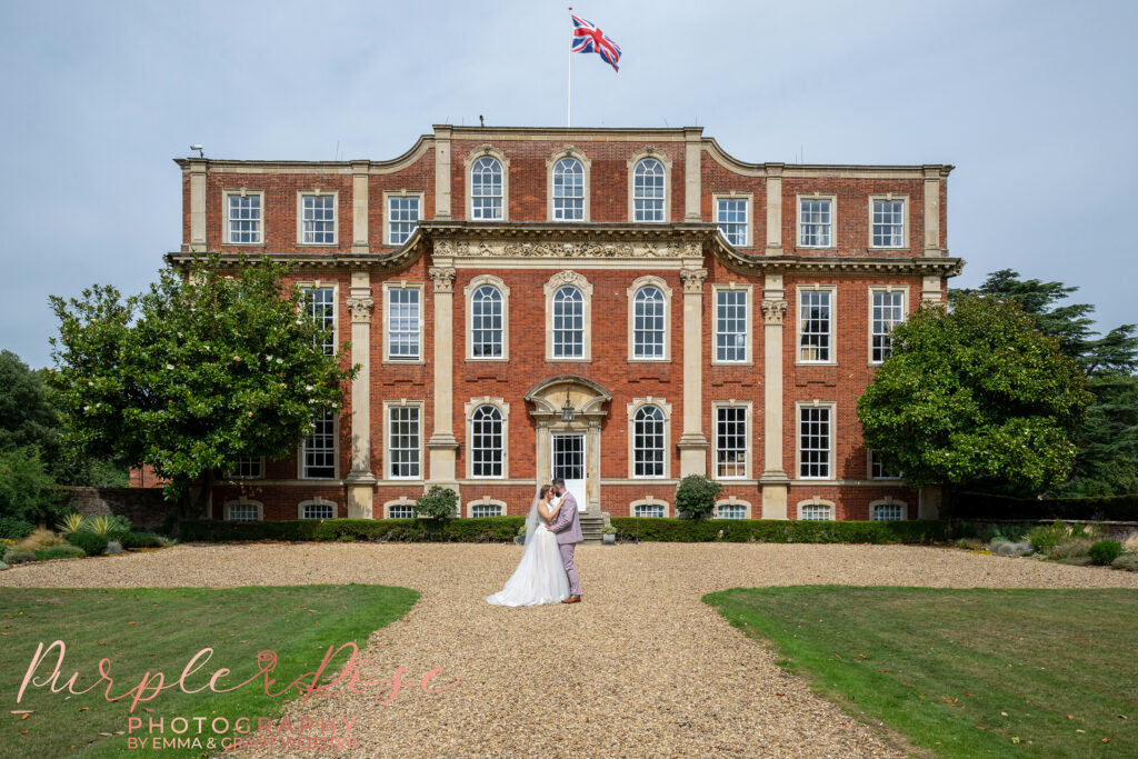Photo of a bride and groom stood in front of Chicheley Hall
