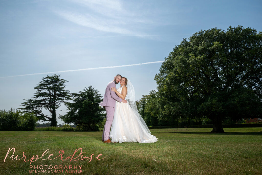 Photo of a bride and groom beautifully lit in the gardens of Chicheley Hall on their wedding day in Milton Keynes