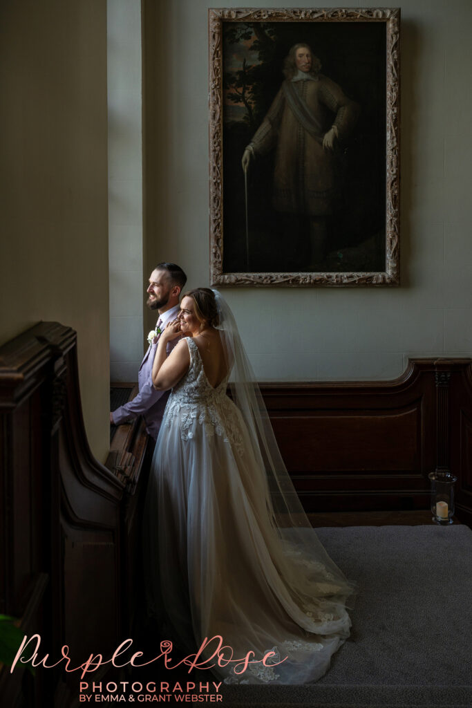 Brie and groom looking out of a window on their wedding day at Chicheley Hall in Milton Keynes